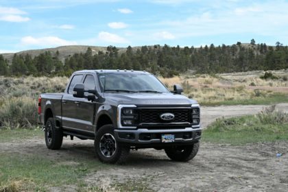 a black truck parked on a dirt road